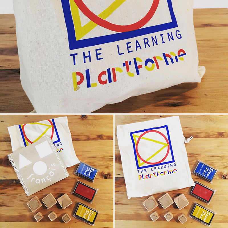 Eve Laguë, some playful objects she has made. Simplistic, allowing those who interact with them to explore playful avenues upon interaction. The objects are geometric stamps, ink pads, a note book, all stored in a blue, yellow and red decorated canvas bag.