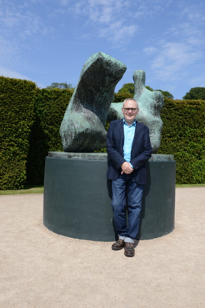 Peter Murray CBE with Chelsea's own Two Piece Reclining Figure No.1 1959, by Henry Moore, at Yorkshire Sculpture Park.
