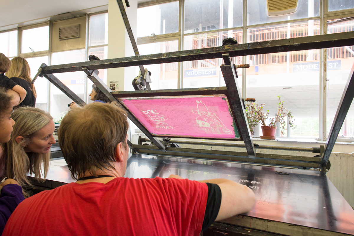 Print Technician Tony Lee checks a screen before printing onto a T Shirt