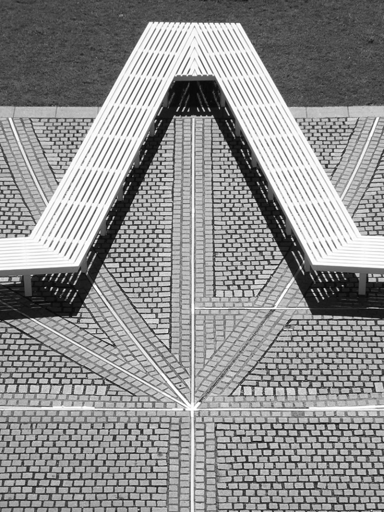 View of Pentagon Petal by artist Fran Cottell and architect Marianne Mueller, an art installation at Chelsea College of Arts, UAL which is open to the public until 30 July 2016. This project on the on the Rootstein Hopkins Parade Ground re-enacts a scaled version of Millbank Prison's plan, editing and reinterpreting it into a more socially active figure: a 120m long flower shaped bench.