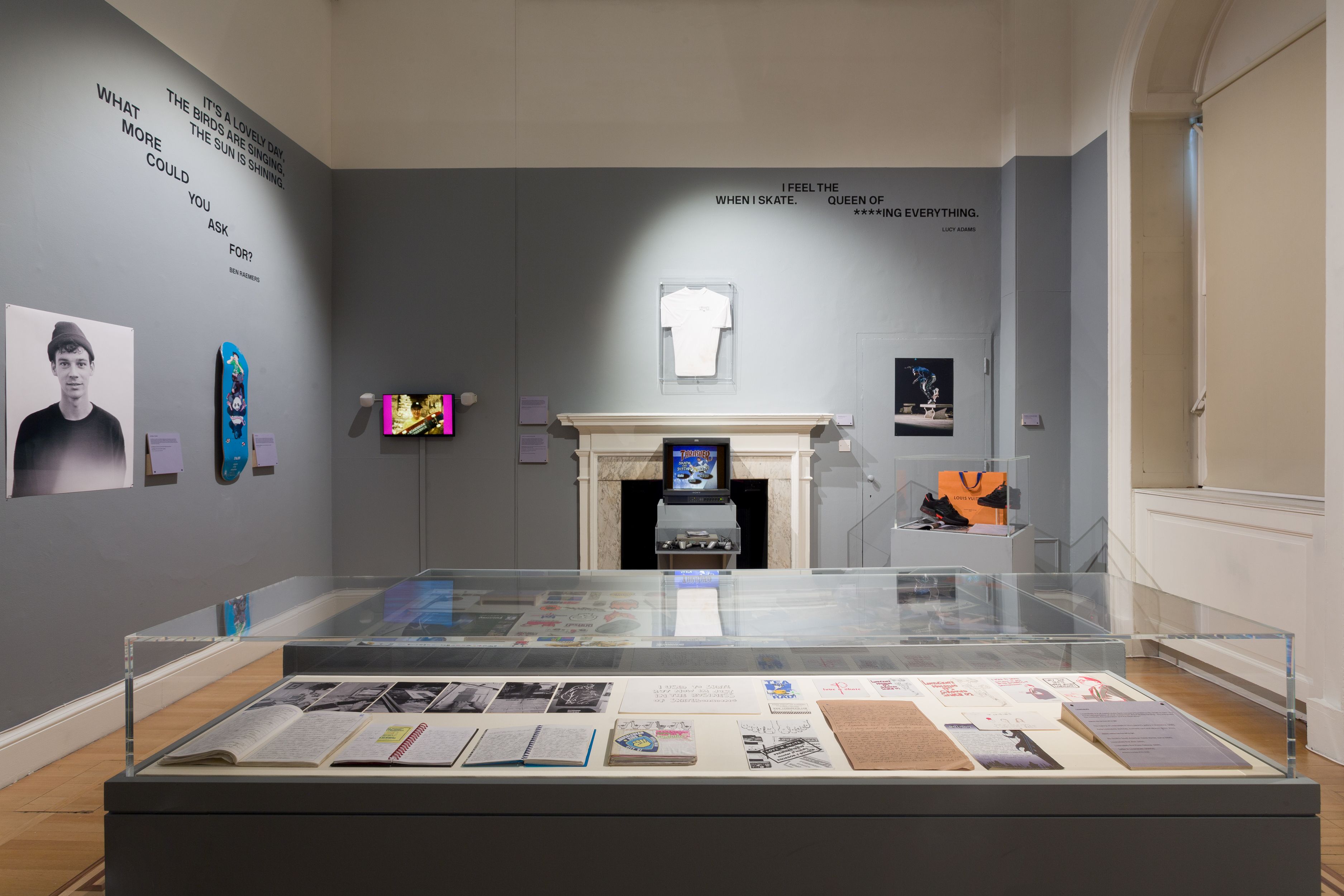 display cases in gallery with t shirt on wall