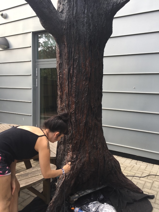 BA Set Design for Screen student painting a life size tree prop for the Virtually Summer set