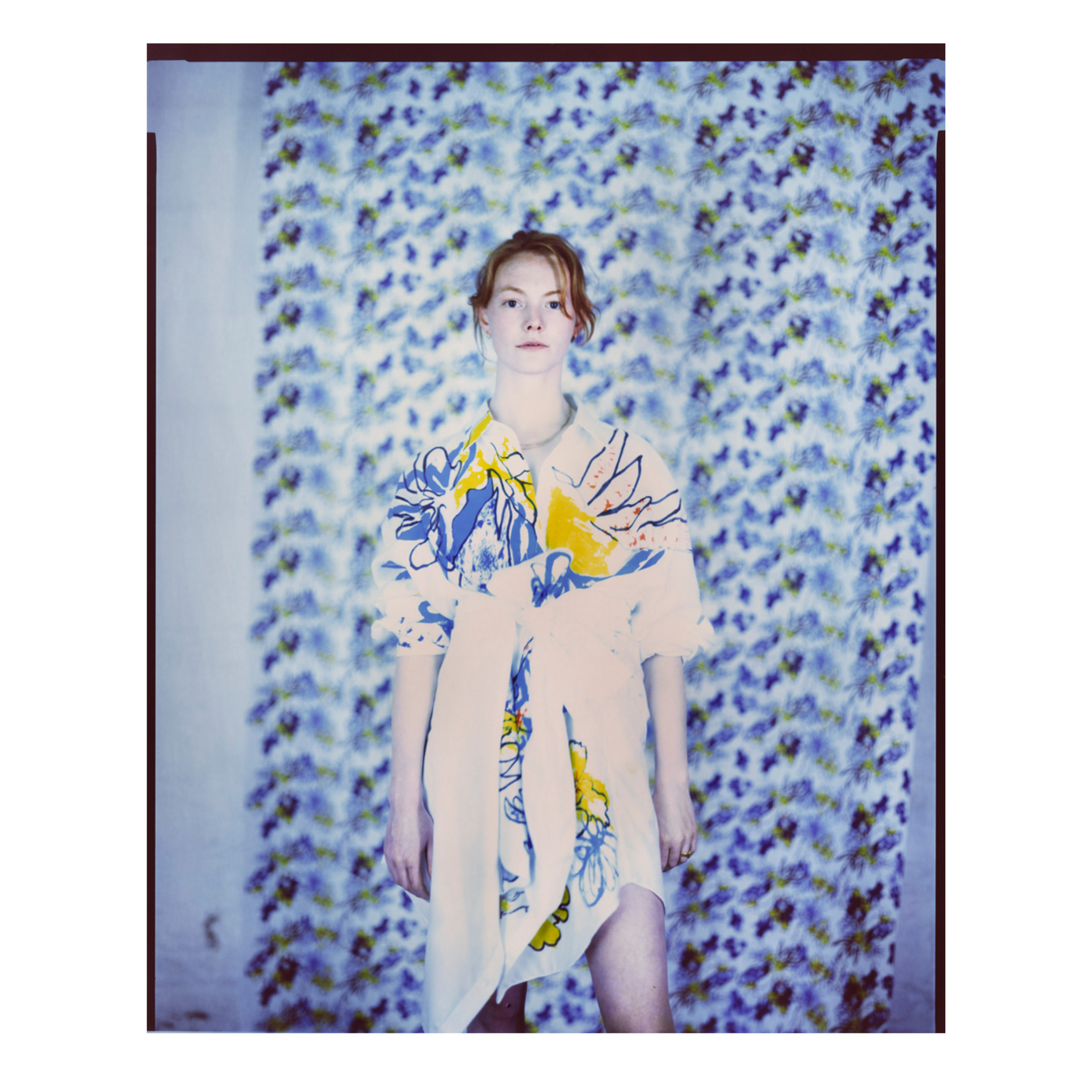 Model posed in front of printed fabric