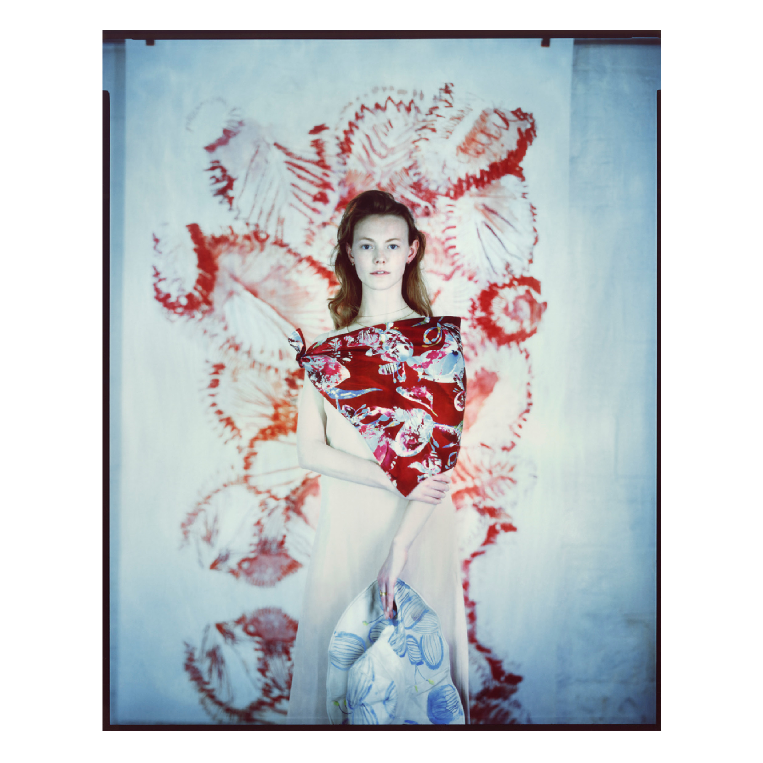 Model posed in front of printed fabric