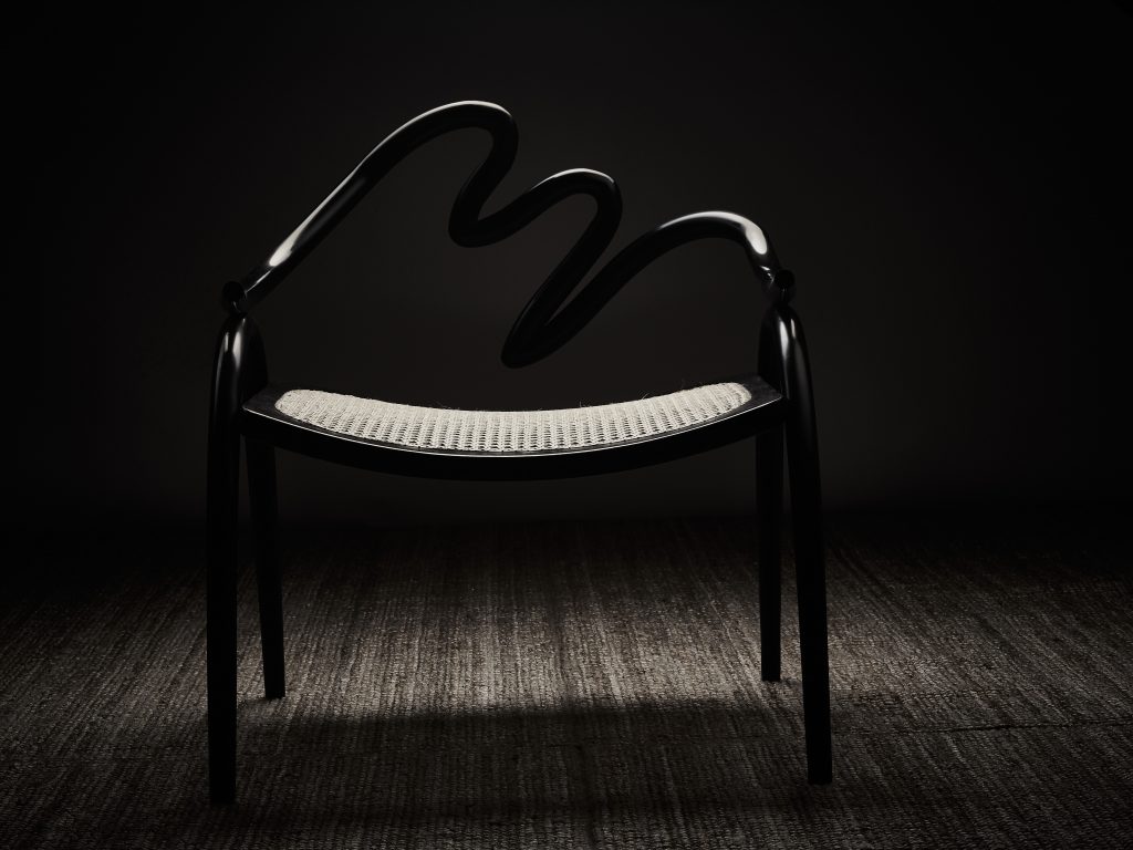 Armchair made from Ebonite, plywood and handwoven cane by Studio Swine