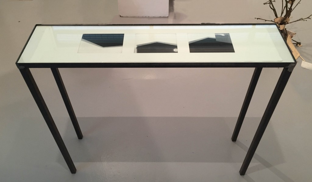UNIT 2016: Harry Walker (BA Photography) - Tavolo. Black metal legged and rimmed glass top table containing 3 pohotgraphic prints of images of the gallery. 