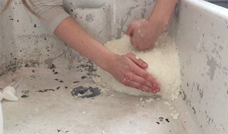 Film still of performance in a sink, 'An edge to decipher, a rim', Lara Kester, soap and liquid soap