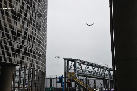 Shot of plane taking off, ascending over the terminal