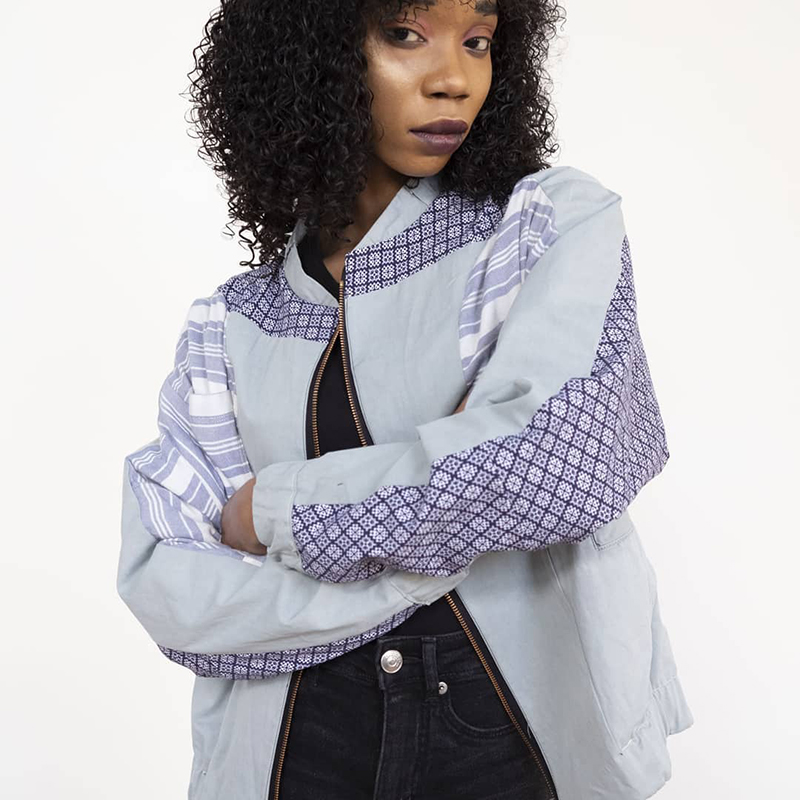 Woman wearing bomber jacket in grey and purple tones