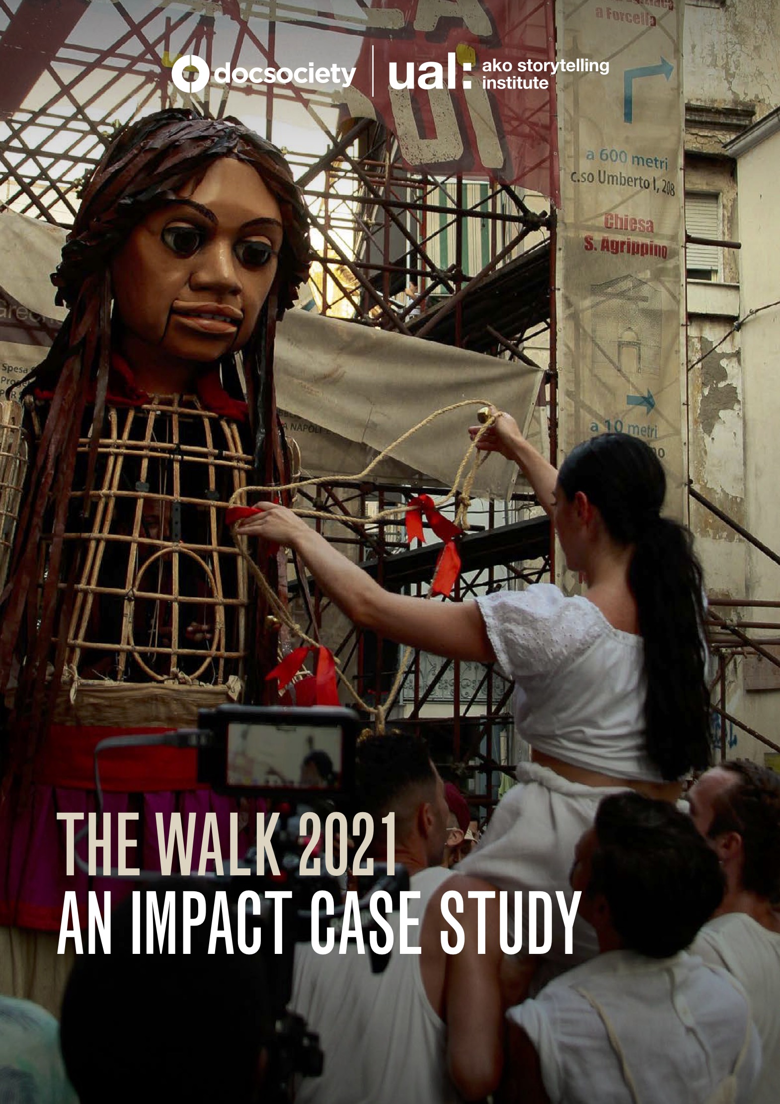 A giant puppet with a crowd in front. The text reads: The Walk 2021 - an Impact Case Study