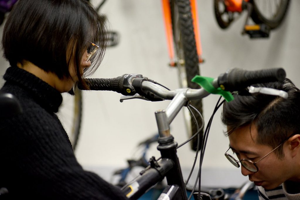 LCC graduates helping to fix bikes at the Bike Project