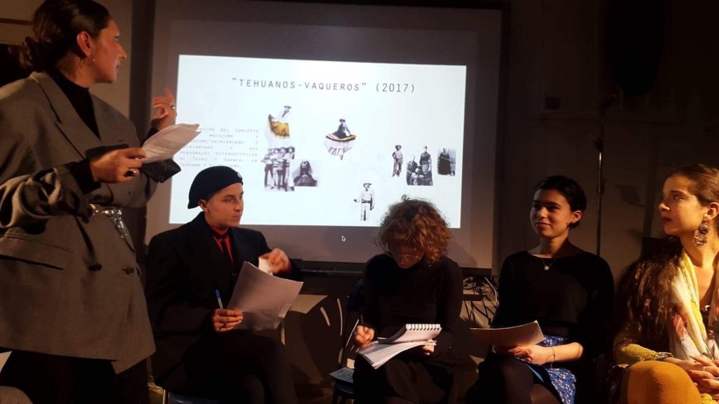 Members on a panel sit in fron of a screen