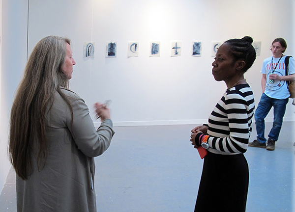 Two women discuss the artwork