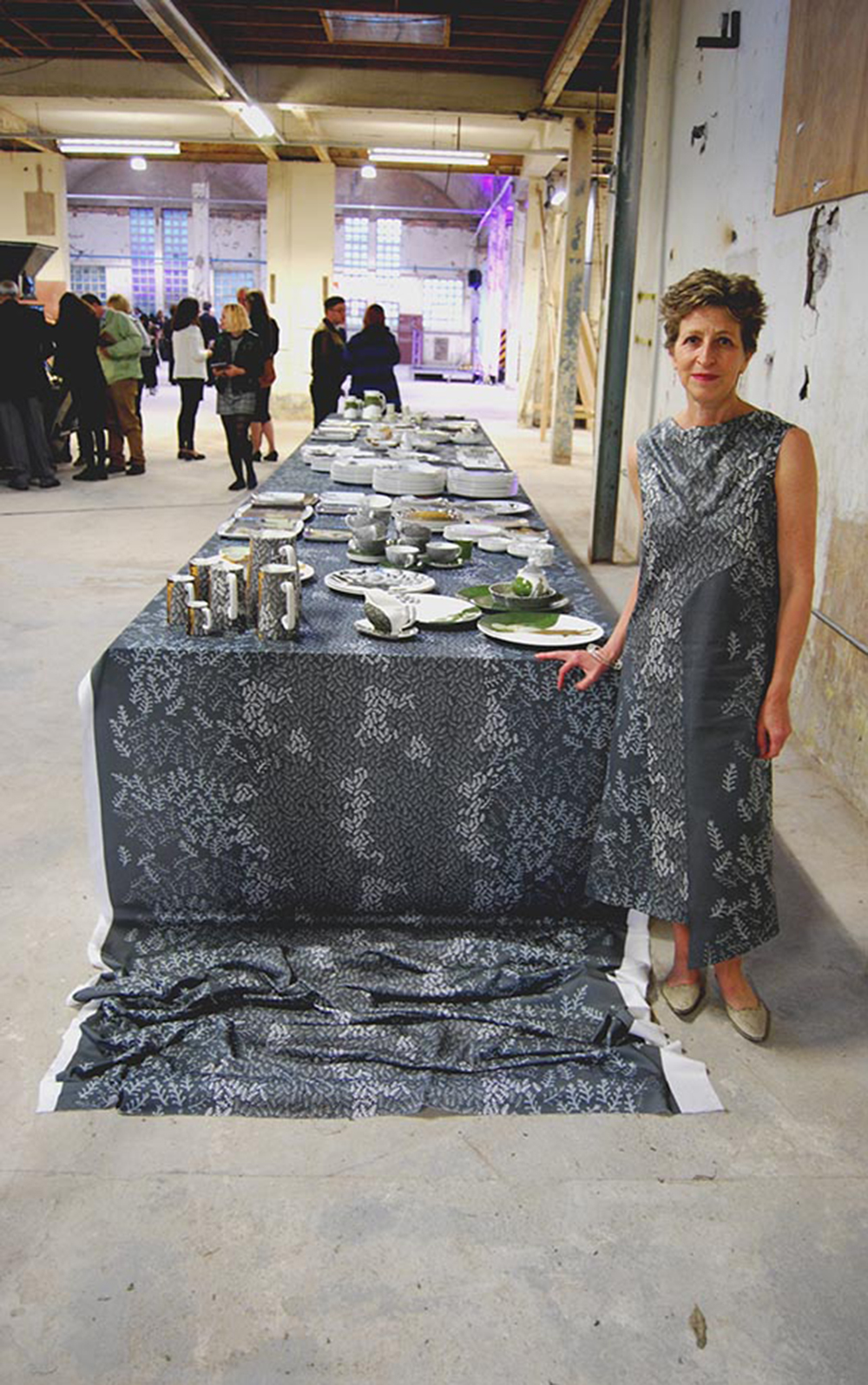 Charlotte Hodes next to the installation wearing a specially commissioned dress made by Wai Han, HO, an LCF MA Costume Design for Performance student