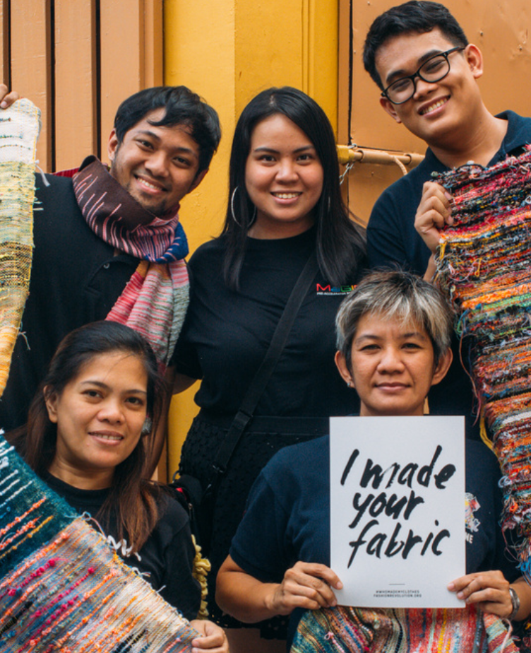 5 garment workers posing, with one holding a sign in the bottom right that reads "I made your fabric"