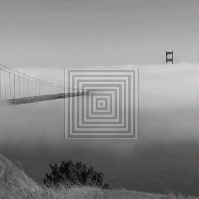 A greyscale image of a bridge disappearing in to cloud.