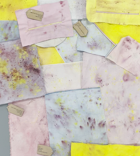 Various purple and yellow dyed fabric swatches on a table.